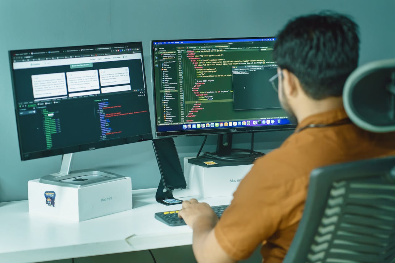 The Art of Drawing Readers In: Your attractive post title goes here A software developer engaged in coding on dual monitors in a modern office setting.